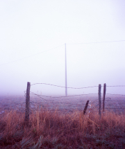 Pylon in the fog, with fence