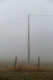 Fence and pylon in the fog