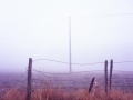 Fence and pylon in the fog